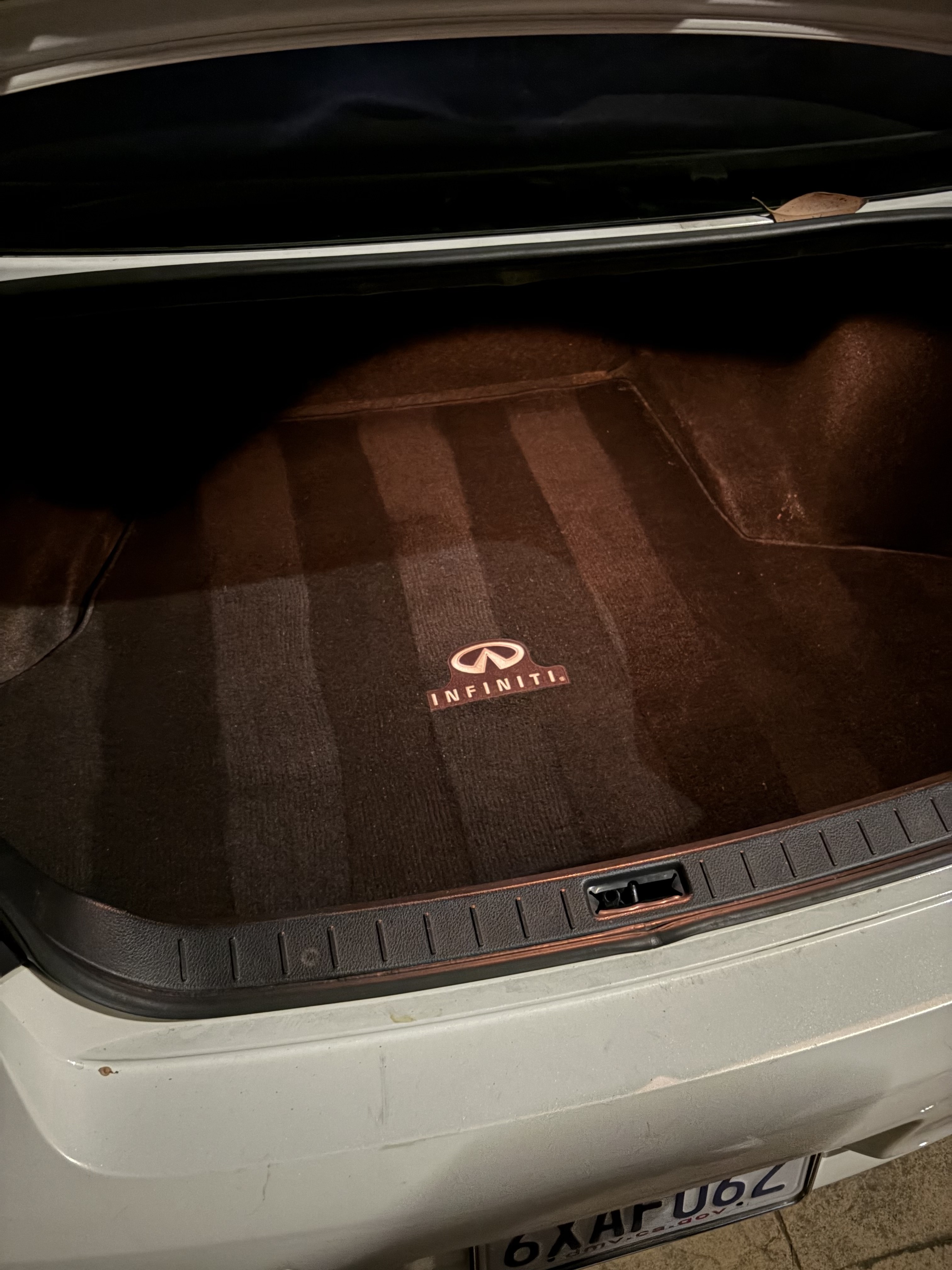 Zoomed-in close up of the pristine chrome Infiniti emblem and brand lettering